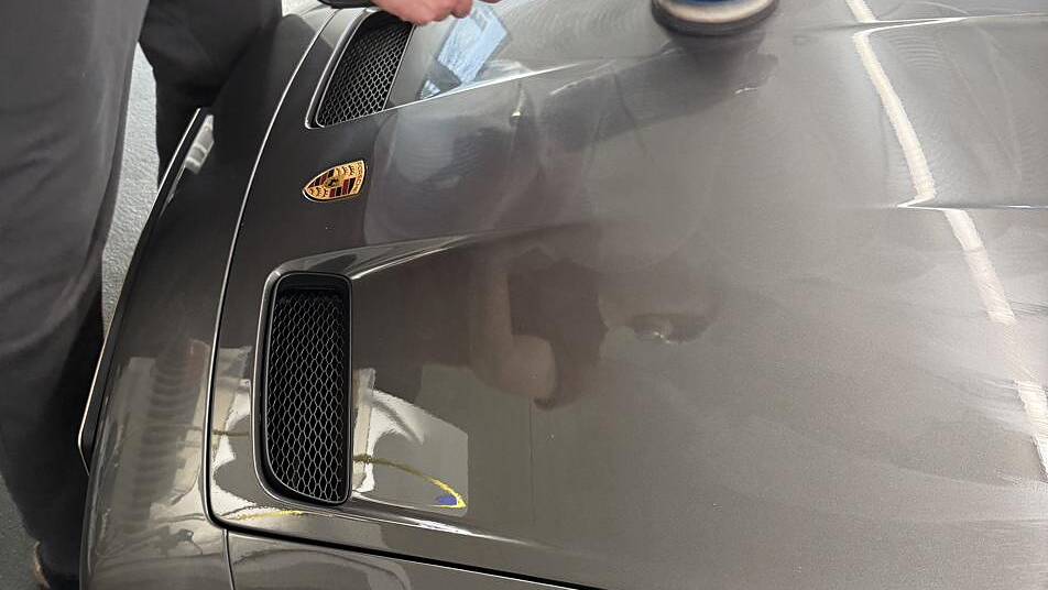 Maschinenpolitur auf der Fronthaube eines Porsche 911