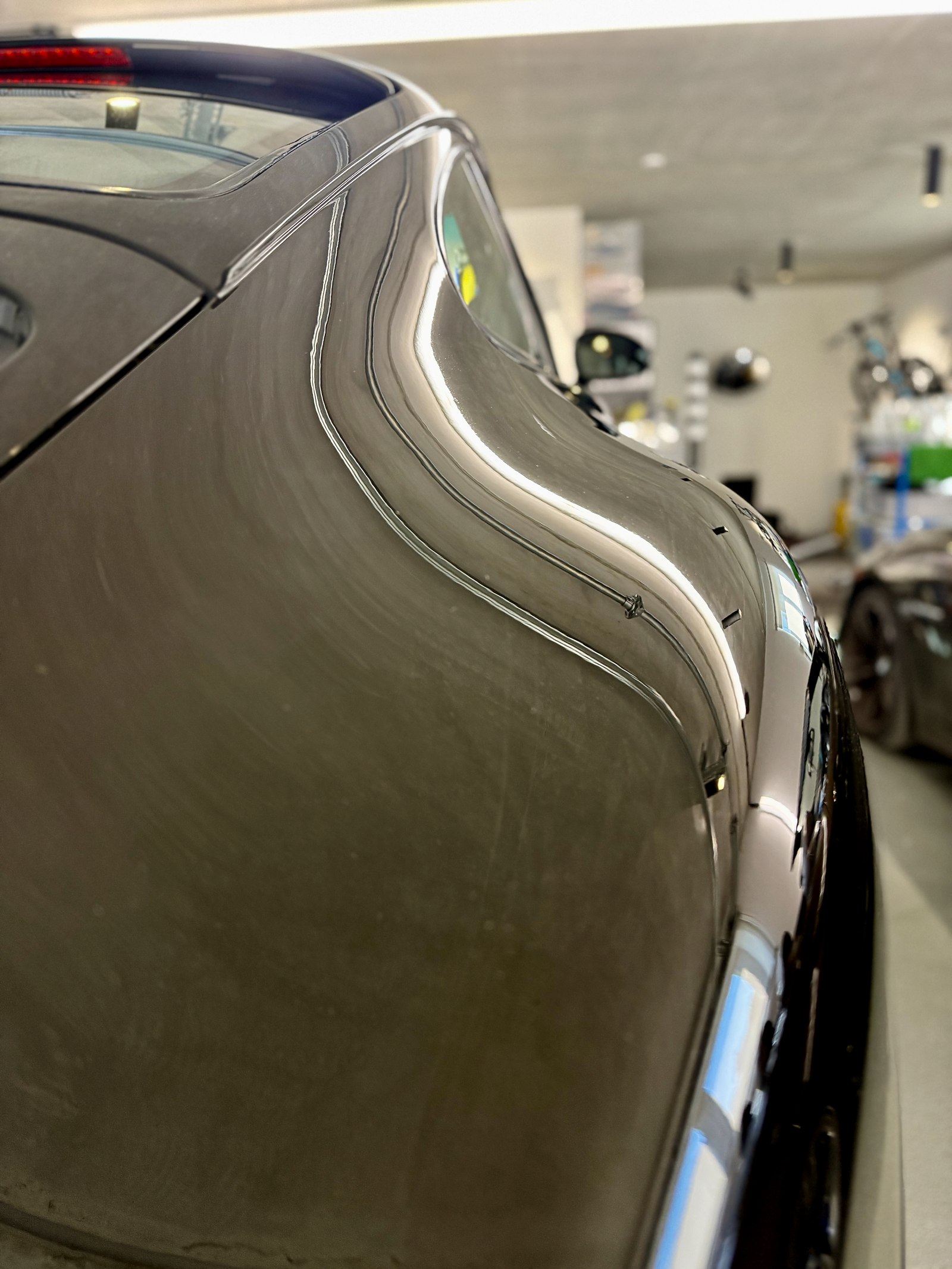 Reflexion im Kotflügel eines schwarzen Porsche nach der Lackkorrektur